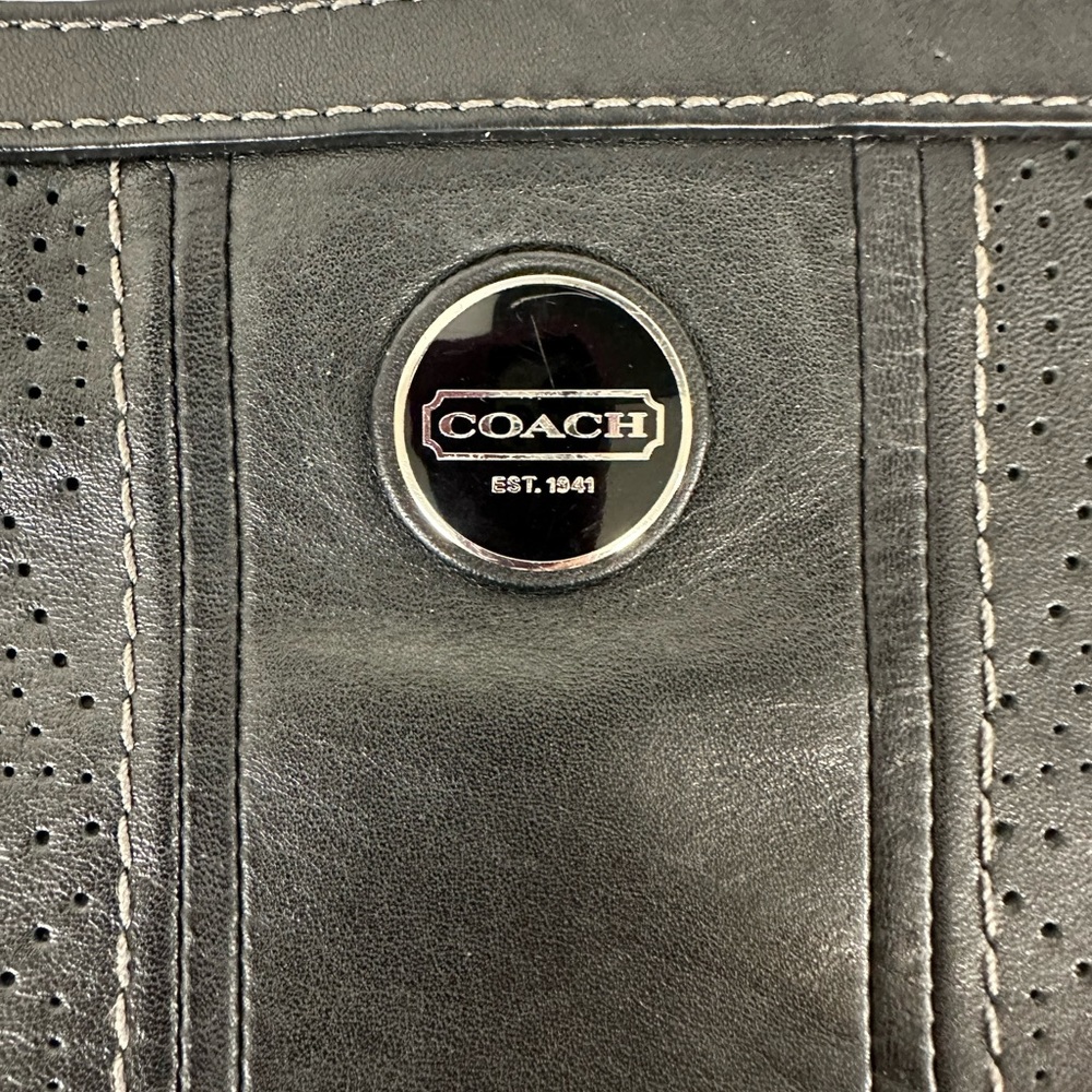Coach black leather shoulder bag with punched “C” hole detail front and back.